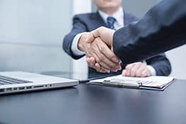 Business partners shaking hands over a project review